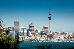 Skyline of Auckland, New Zealand with modern skyscrapers and iconic Sky Tower in the center.