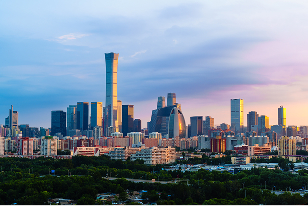 Skyline of towering skyscrapers in downtown Beijing, China against a colorful evening sky.