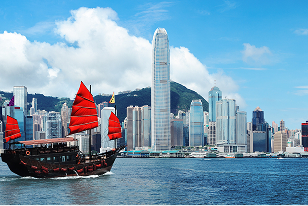 Majestic skyline of Hong Kong, with iconic skyscrapers and a traditional Chinese junk boat in the foreground.